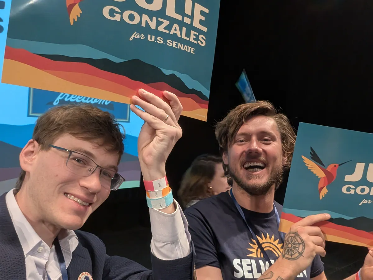 Jack and Max Lord holding Julie Gonzales for U.S. Senate signs at the state assembly