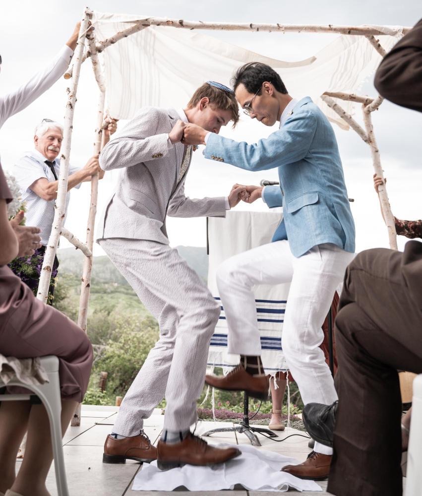 Jack and his husband break the wine glasses at their wedding