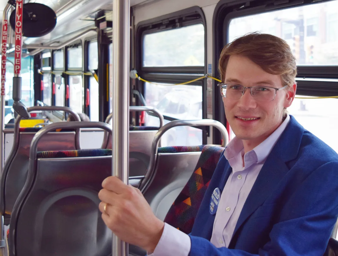 Jack Rosenthal seated on an RTD bus, holding the pole